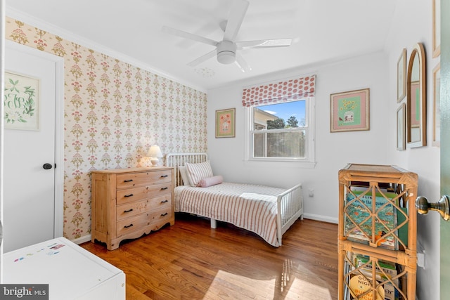 bedroom with wallpapered walls and wood finished floors