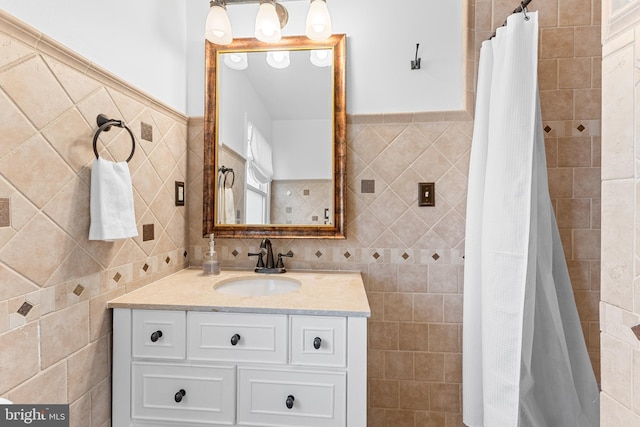 bathroom featuring a shower with curtain, tile walls, and vanity