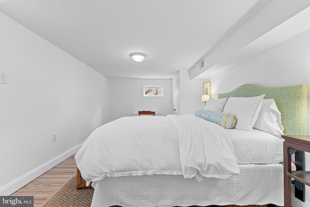 bedroom with light wood-type flooring, visible vents, and baseboards