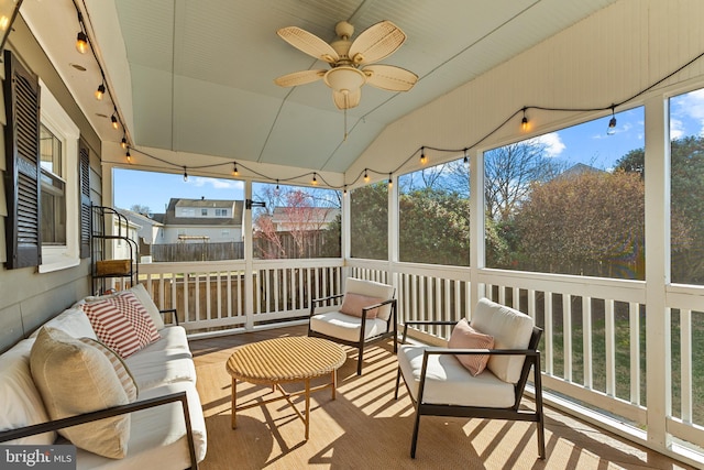 sunroom with a wealth of natural light, rail lighting, lofted ceiling, and a ceiling fan