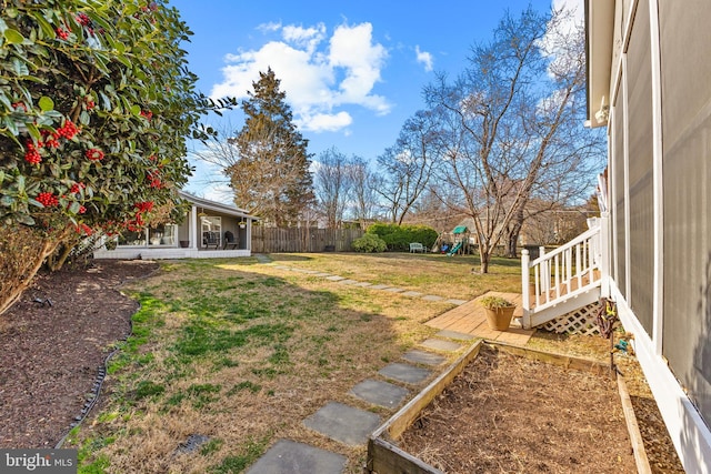 view of yard featuring a garden, fence, and a playground