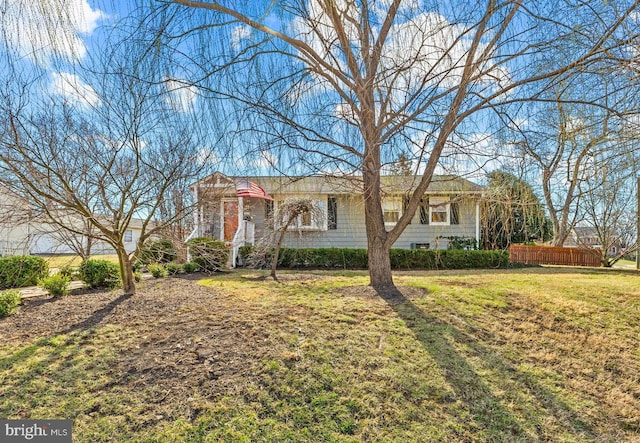 ranch-style home with a front lawn and fence