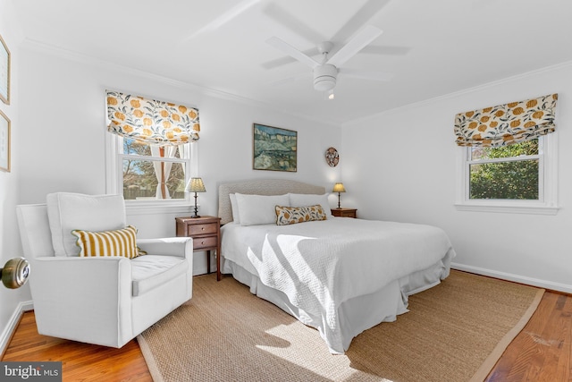 bedroom with light wood-style flooring, ornamental molding, and multiple windows