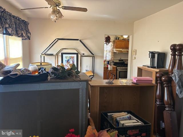 kitchen featuring stainless steel gas range oven and a ceiling fan