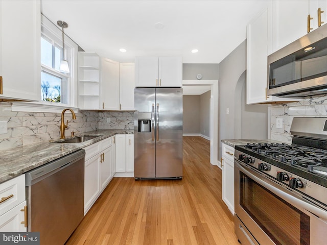 kitchen featuring a sink, light stone countertops, white cabinetry, and stainless steel appliances