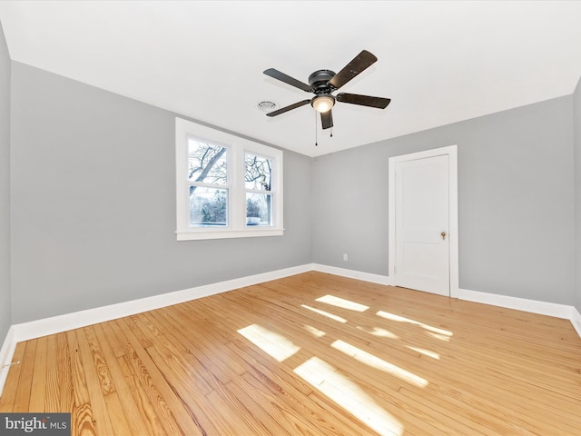 spare room with ceiling fan, baseboards, and wood finished floors