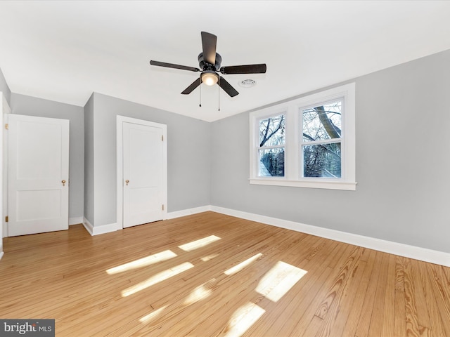 unfurnished bedroom with a closet, baseboards, light wood-style floors, and ceiling fan