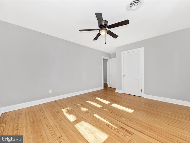 unfurnished room featuring visible vents, a ceiling fan, baseboards, and wood finished floors