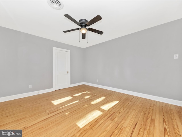 spare room featuring visible vents, ceiling fan, baseboards, and hardwood / wood-style floors