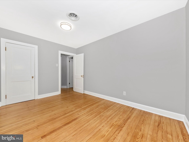 unfurnished bedroom featuring visible vents, light wood-type flooring, and baseboards