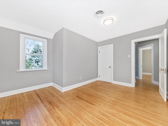 unfurnished bedroom featuring visible vents, light wood-style floors, and baseboards