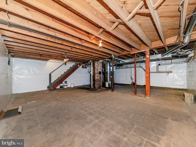 unfinished basement with heating unit and stairs