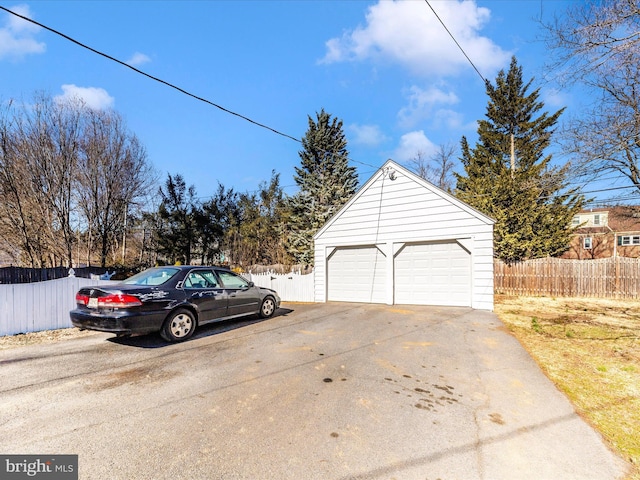 detached garage featuring fence