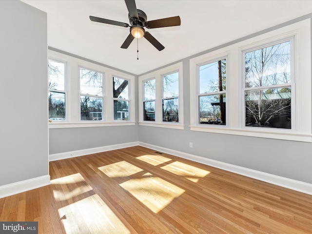 unfurnished sunroom featuring a ceiling fan, a healthy amount of sunlight, and visible vents