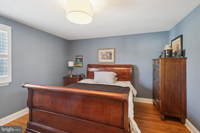 bedroom with wood finished floors and baseboards