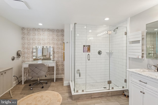 bathroom with vanity, radiator, wood tiled floor, recessed lighting, and a stall shower