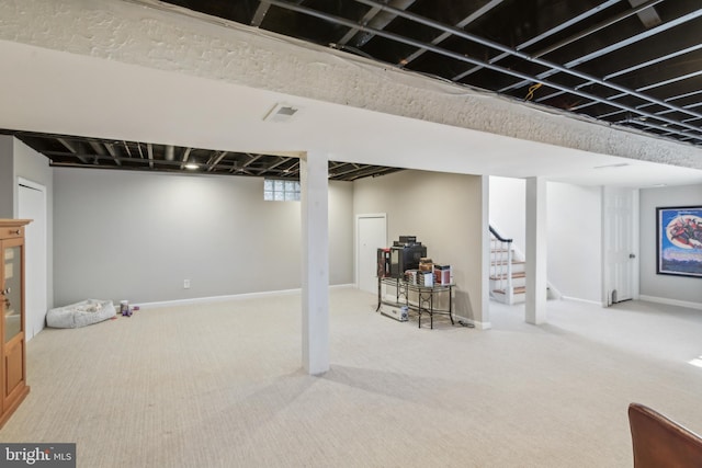 below grade area with stairway, carpet flooring, visible vents, and baseboards