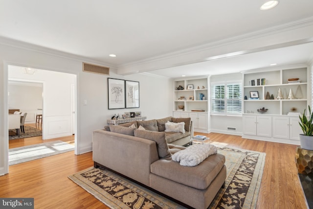 living area with recessed lighting, visible vents, light wood finished floors, and ornamental molding