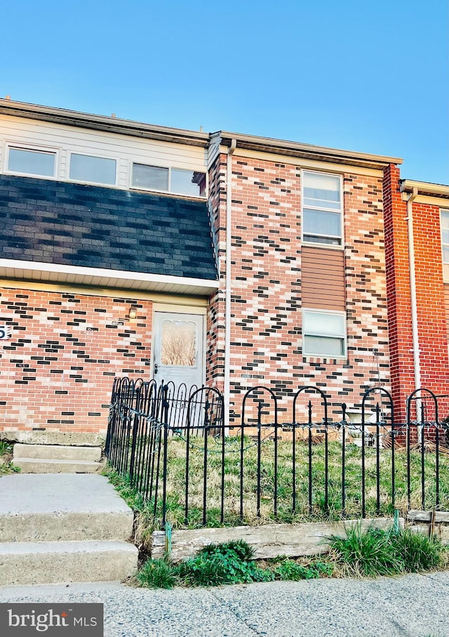 view of front of home with fence and brick siding