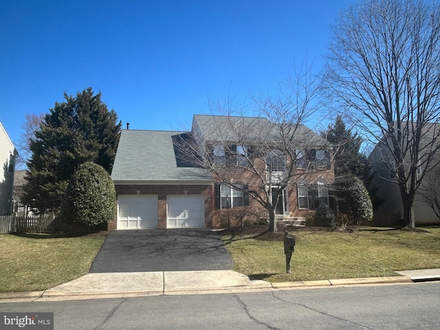 view of front of home with driveway, a front lawn, fence, a garage, and brick siding