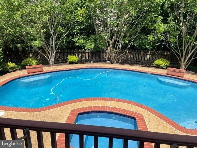 view of swimming pool with a fenced in pool, an in ground hot tub, and a fenced backyard