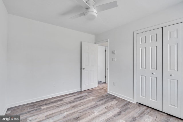 unfurnished bedroom with a closet, ceiling fan, light wood-type flooring, and baseboards