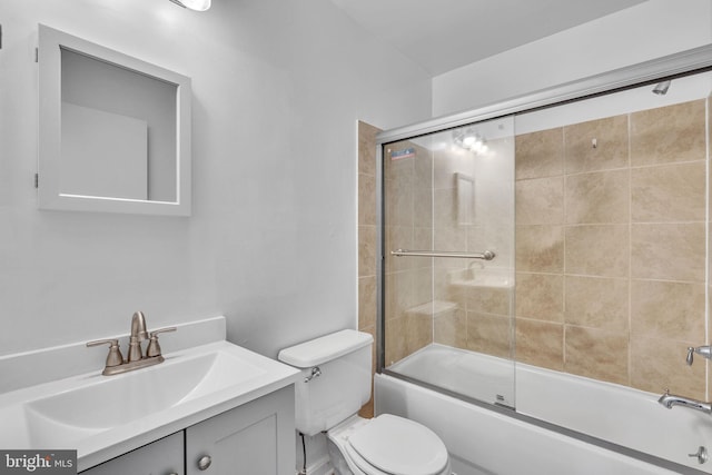 bathroom with combined bath / shower with glass door, toilet, and vanity