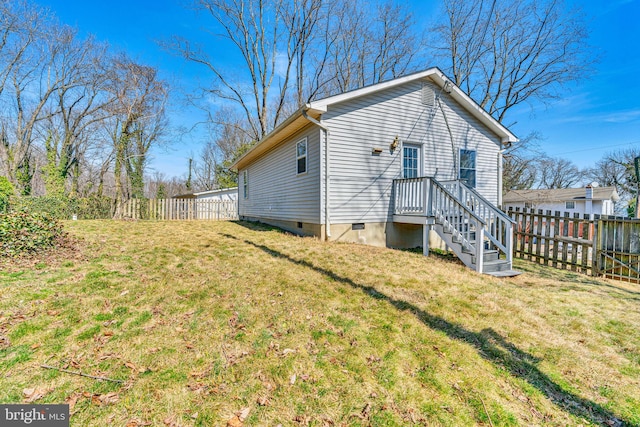 back of property with crawl space, a lawn, and fence