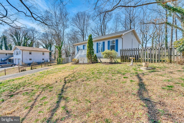 view of front facade featuring a front yard and fence