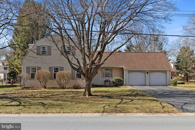 view of front of home with a garage, driveway, a front lawn, and roof with shingles