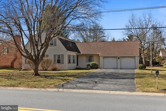 view of front of house featuring a garage, driveway, a shingled roof, and a front yard