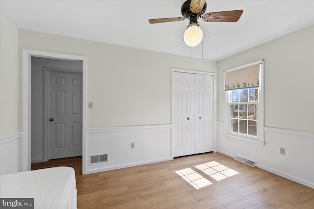 unfurnished bedroom featuring a closet, visible vents, light wood-style flooring, and baseboards