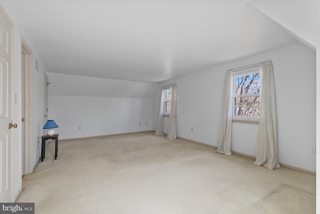 bonus room with baseboards, light colored carpet, and vaulted ceiling