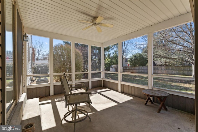 unfurnished sunroom featuring ceiling fan