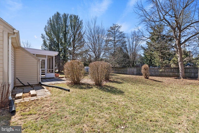 view of yard featuring fence and a sunroom