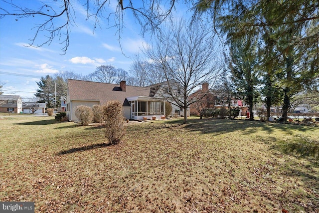 view of yard with a garage and a sunroom