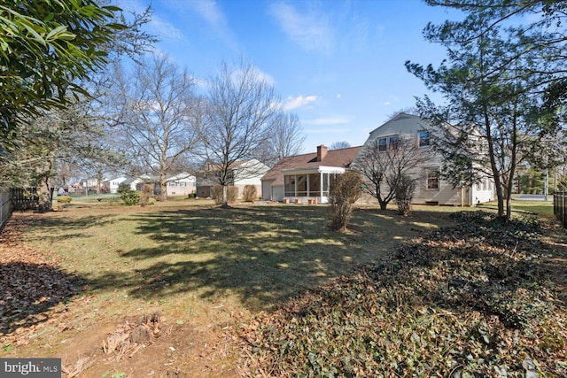 view of yard featuring a sunroom and fence