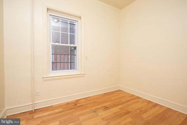 unfurnished room featuring baseboards and light wood finished floors