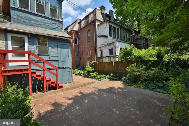 view of property exterior featuring roof with shingles and fence