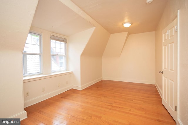 additional living space featuring baseboards and light wood-style flooring