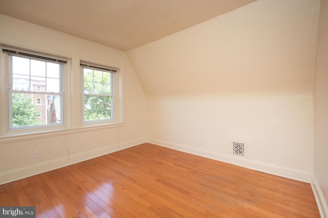 additional living space featuring vaulted ceiling, visible vents, baseboards, and light wood finished floors