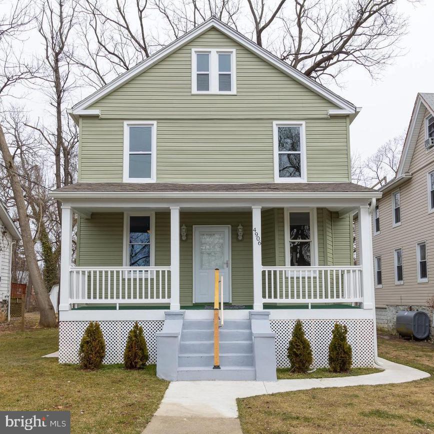 american foursquare style home with a front lawn, heating fuel, and covered porch