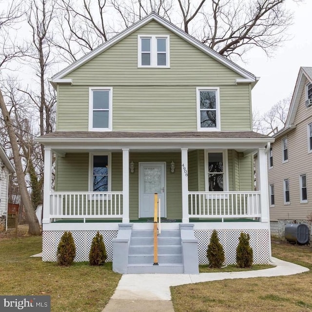 american foursquare style home with a front lawn, heating fuel, and covered porch