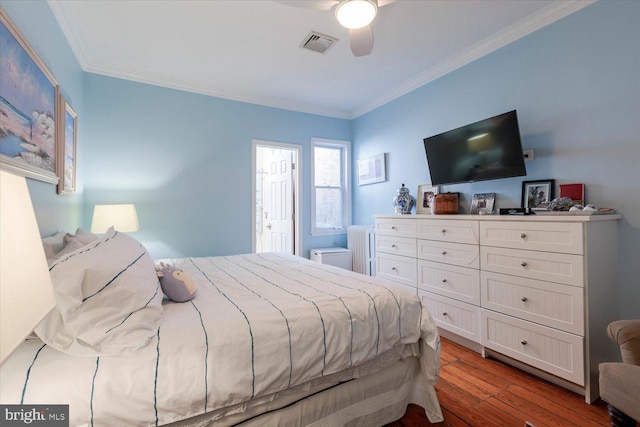 bedroom featuring visible vents, crown molding, radiator heating unit, wood finished floors, and a ceiling fan