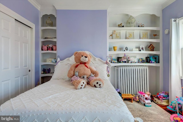 bedroom with crown molding, radiator, and a closet