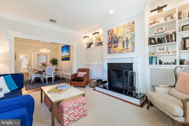 living room featuring visible vents, a notable chandelier, a fireplace with raised hearth, ornamental molding, and built in features