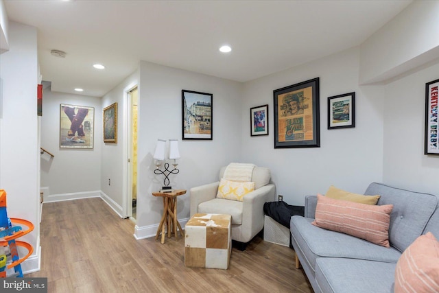 living area featuring recessed lighting, baseboards, and light wood-type flooring