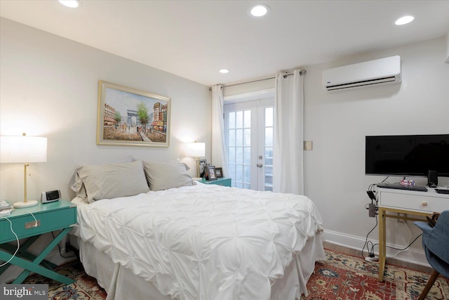 bedroom featuring a wall unit AC, recessed lighting, french doors, and wood finished floors