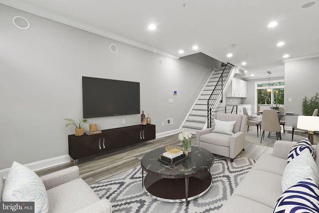 living area with stairway, recessed lighting, light wood-type flooring, and ornamental molding