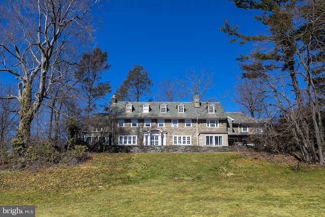 back of property with a yard and a chimney